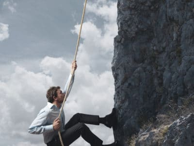 Resilient Man Scaling Cliff