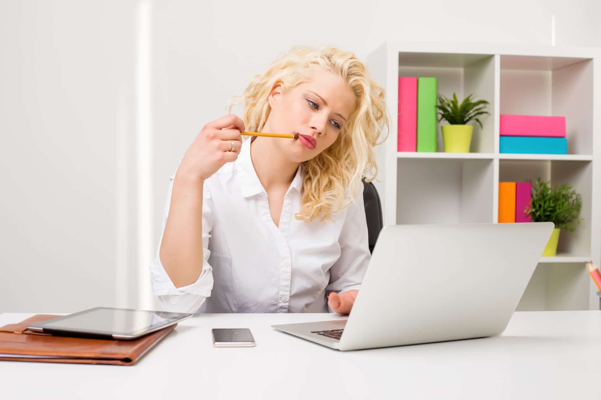 Woman trying to make a decision as she stares at her laptop.