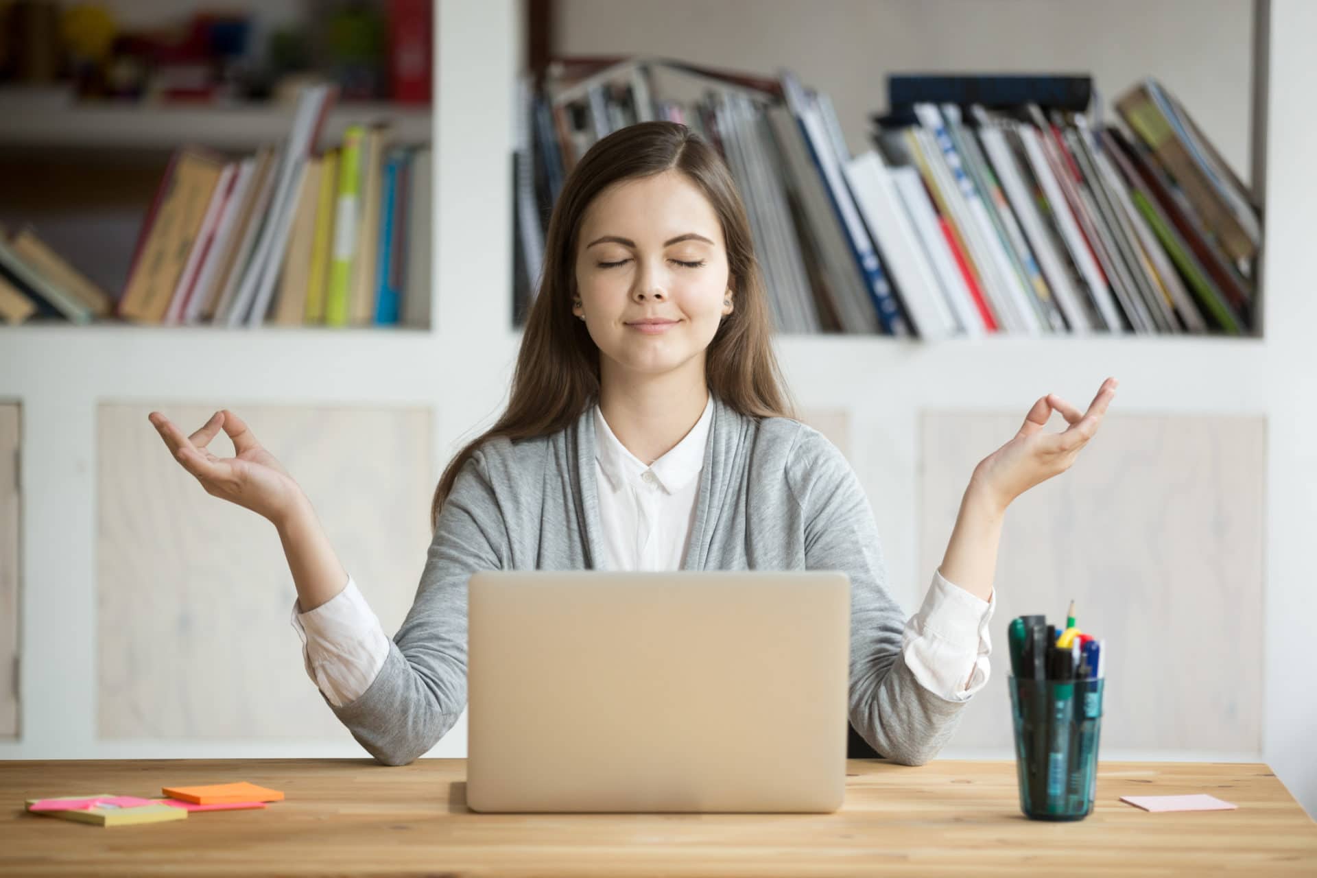 Woman meditating and being mindful at her desk at work