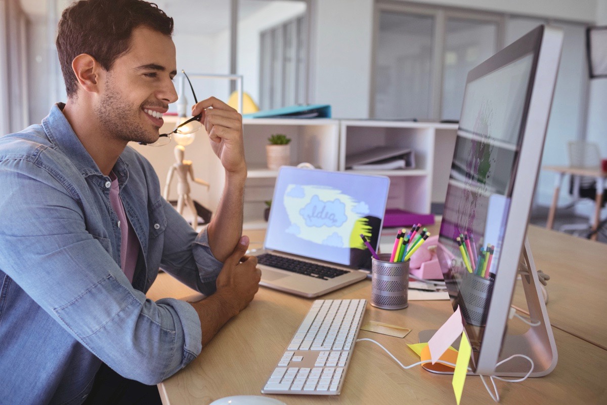 Smiling businessman looking at computer in office