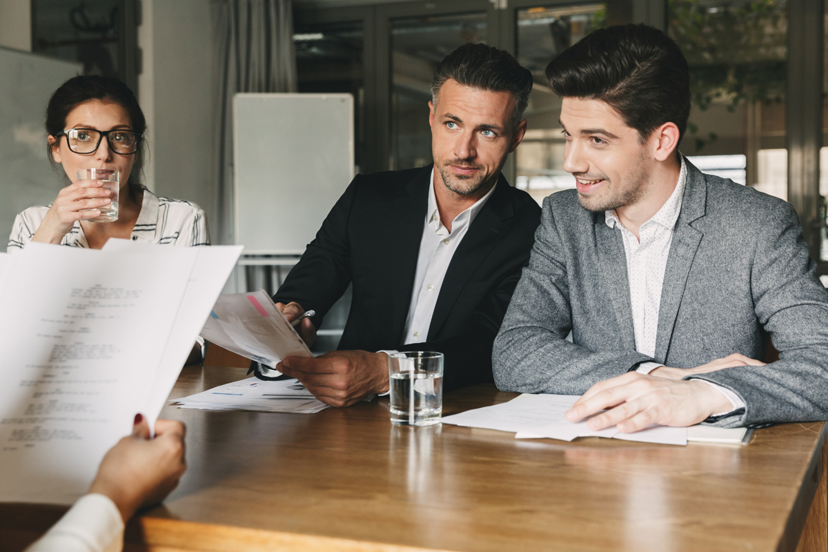 Group of managers contemplating the answers given by a candidate.