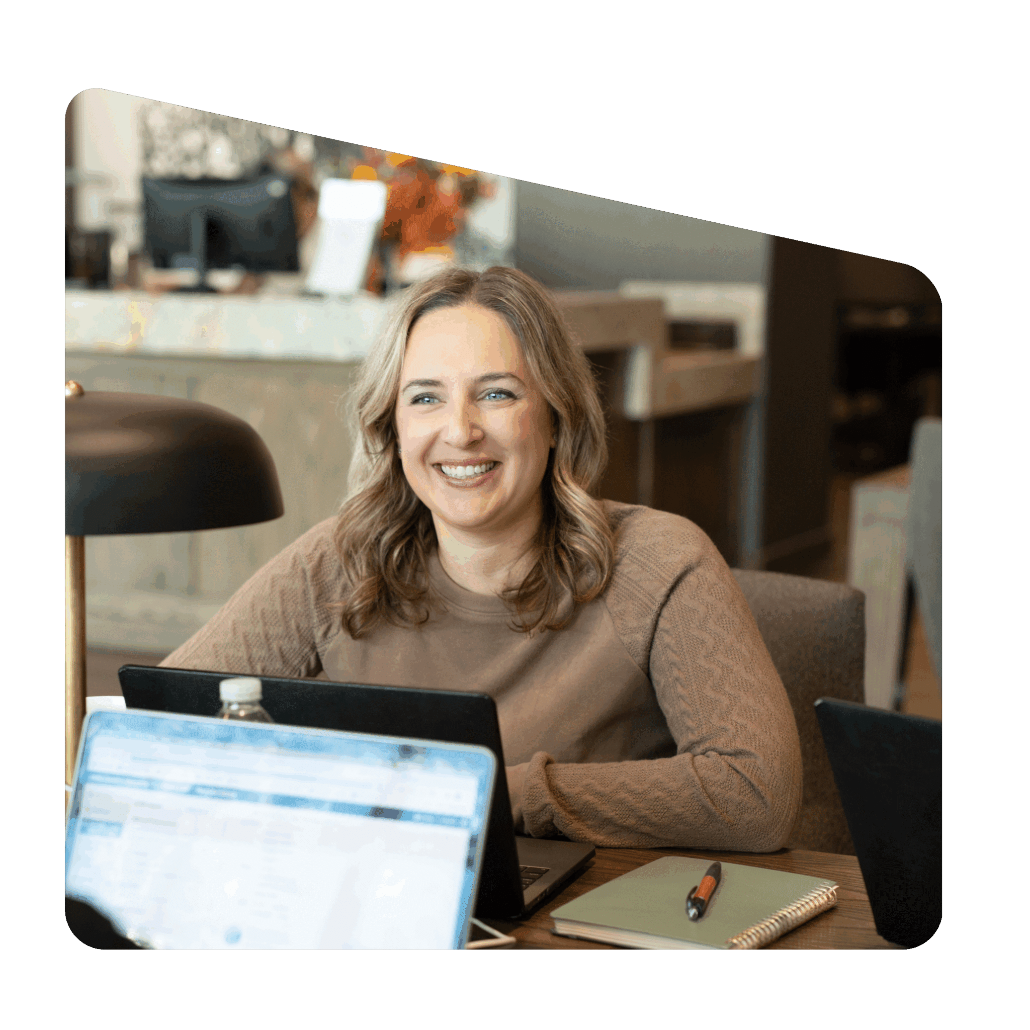 Recruiter smiling while working at desk with laptop and notebook